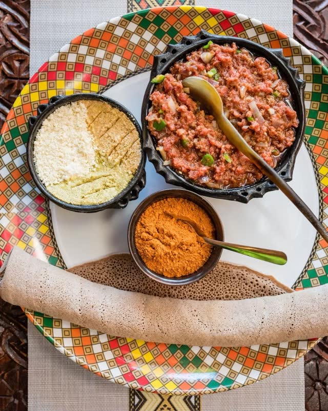 Dulet kitfo with cottage cheese and mitmita on a woven platter
