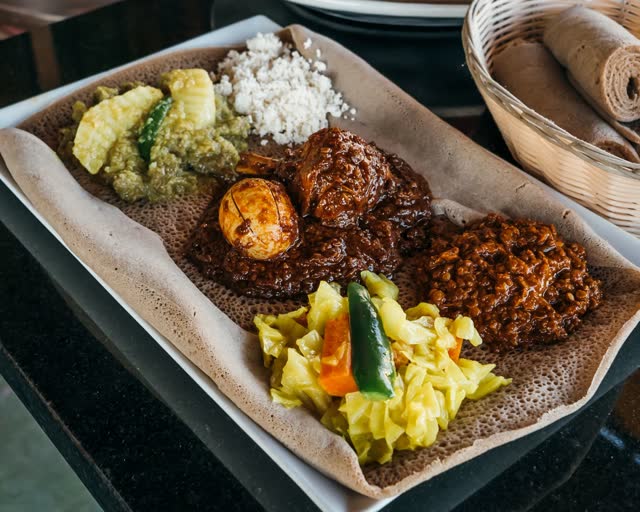 Two meat and two veggie sampler on injera